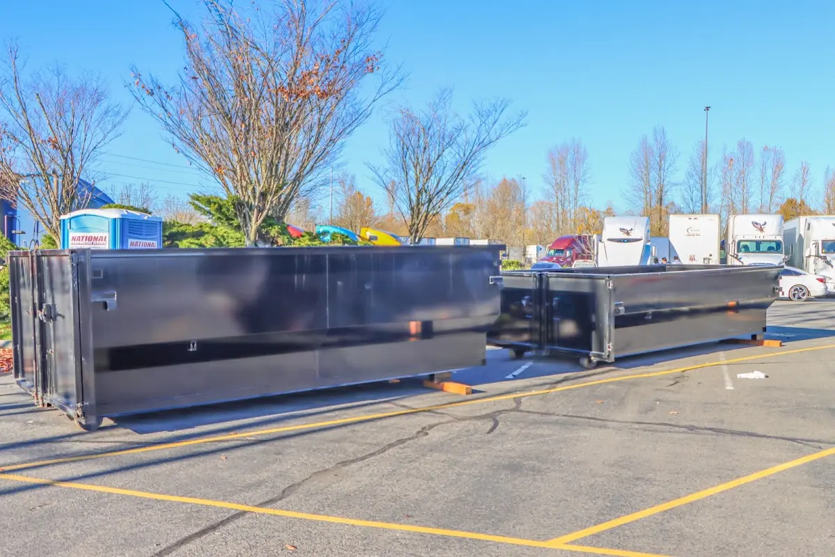 Professional dumpster rental service with roll-off container on residential driveway in Vine Grove